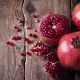 Some Red Pomegranates On Old Wooden Table