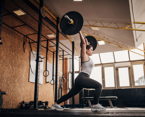 Fit woman training with weights in gym