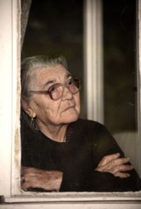 Alte Frau wartend am Fenster